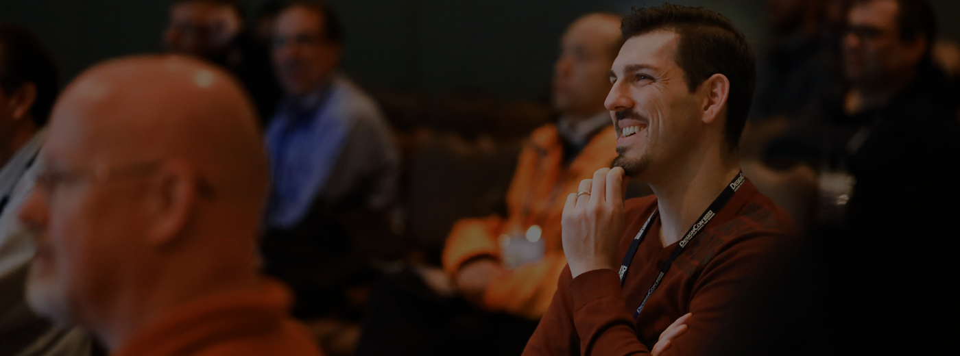 Gentleman smiles while listing to a speaker photo